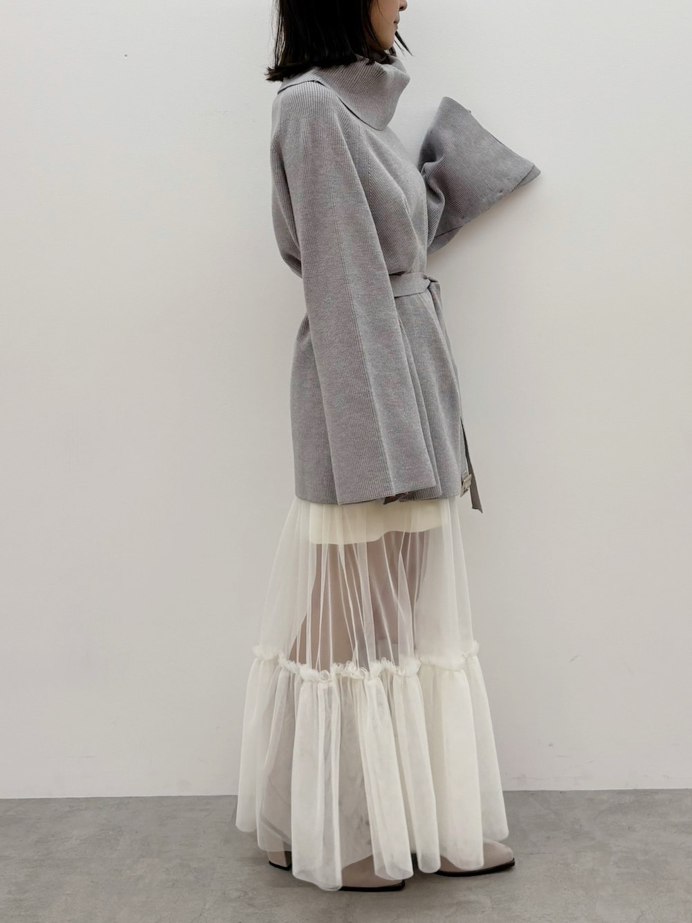 グレー系のニット/セーター、グレー系のブーツ、ホワイト系のスカートを着用したレディースの秋コーディネートの8枚目の写真