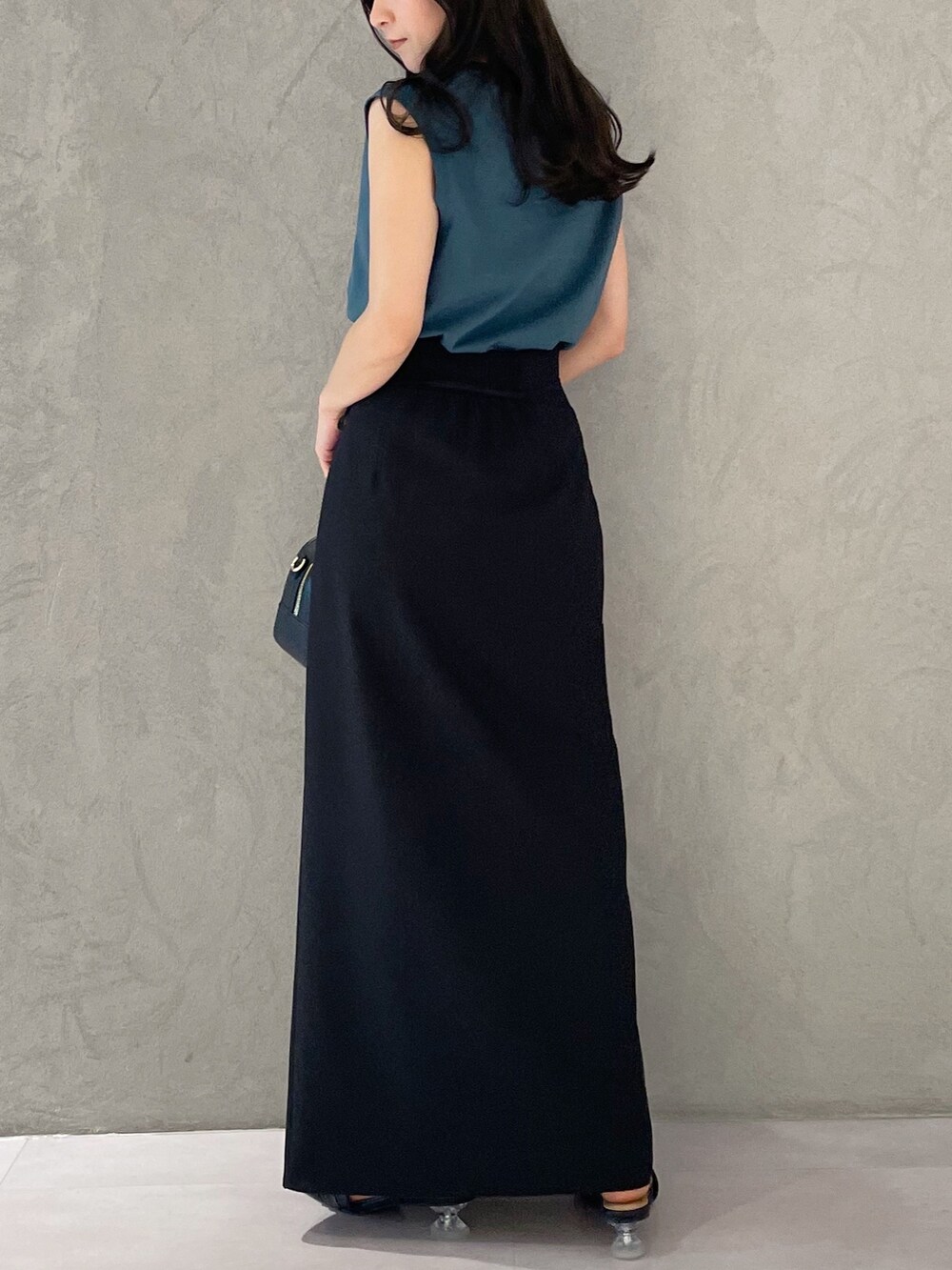 ブラック系のスカート、ブラック系のサンダル、ブラック系のボストンバッグを着用したレディースの春コーディネートの5枚目の写真