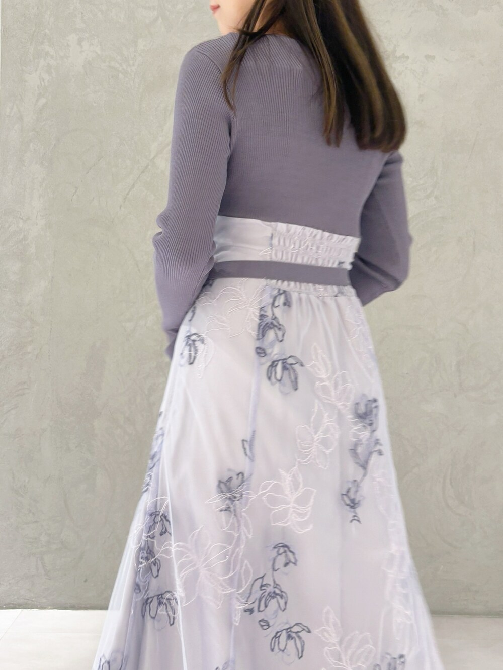 パープル系のワンピース、ブラック系のブーツ、ホワイト系のハンドバッグを着用したレディースの秋コーディネートの3枚目の写真