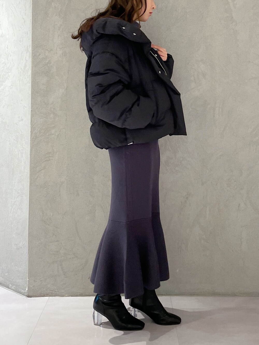 ブラック系のダウンジャケット/コート、ブルー系のワンピース、ブラック系のブーツを着用したレディースの冬コーディネートの2枚目の写真