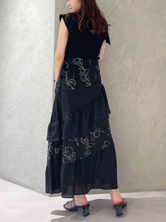 ブラック系のショルダーバッグ、ブラック系のニット/セーター、ブラック系のスカートを着用したレディースの夏コーディネートの6枚目の写真