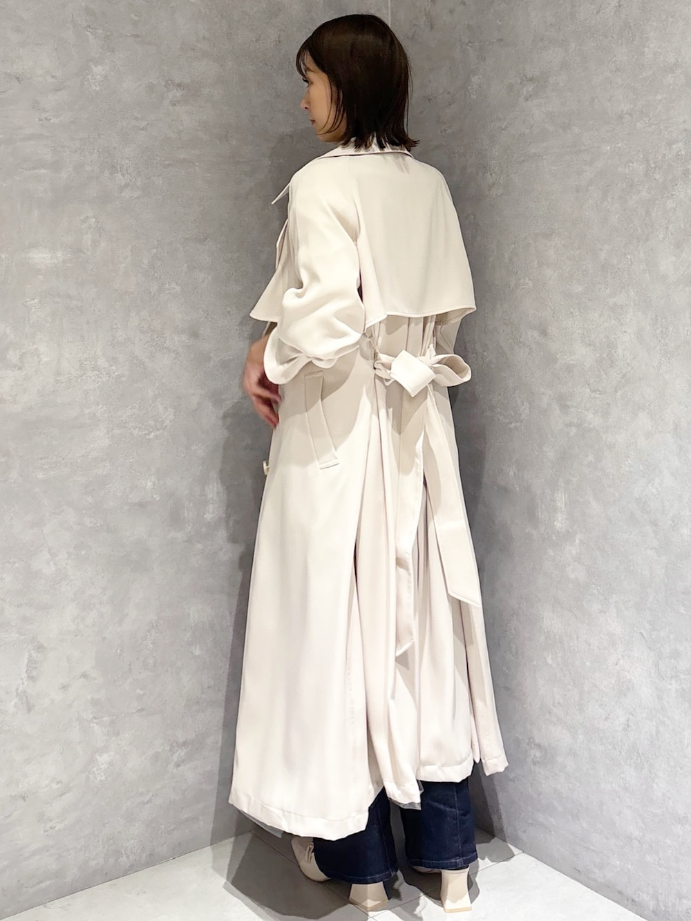 ブルー系のデニムパンツ、ホワイト系のパンプス、イエロー系のニット/セーターを着用したレディースの冬コーディネートの3枚目の写真