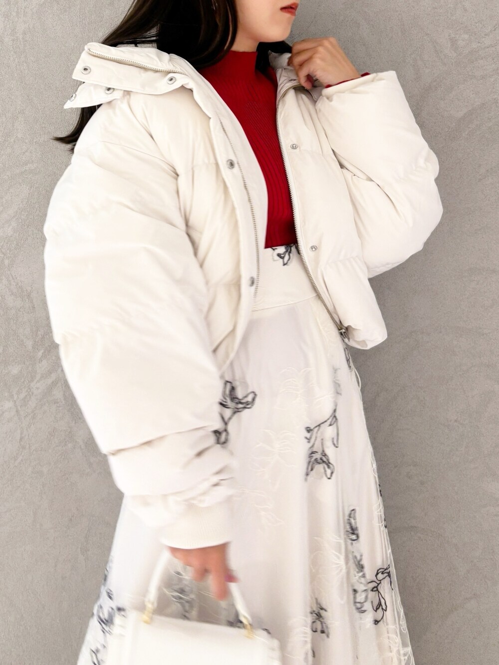 ホワイト系のスカート、ブラック系のブーツ、ホワイト系のハンドバッグを着用したレディースの冬コーディネートの6枚目の写真