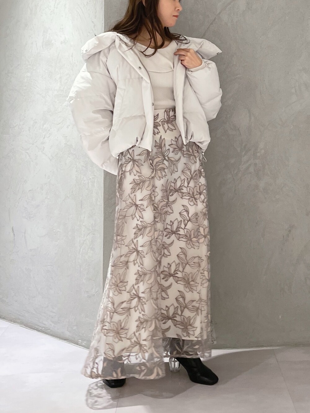 ホワイト系のダウンジャケット/コート、ホワイト系のニット/セーター、ピンク系のスカートを着用したレディースの冬コーディネートの2枚目の写真