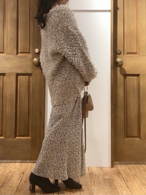 ホワイト系のスカート、ホワイト系のニット/セーター、グレー系のカーディガン/ボレロを着用したレディースの冬コーディネートの2枚目の写真