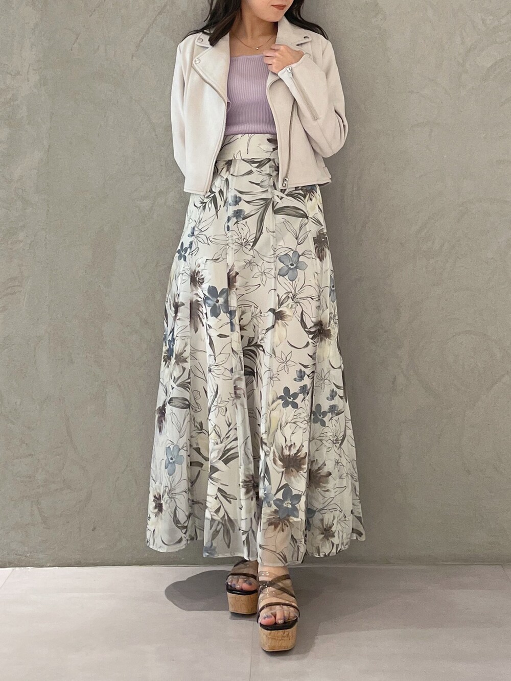 グリーン系のスカート、ピンク系のライダースジャケット、ブラック系のサンダルを着用したレディースの春コーディネートの4枚目の写真