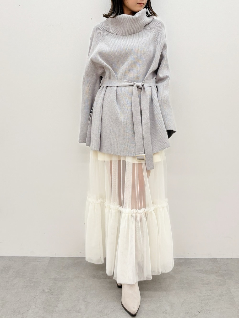 グレー系のニット/セーター、グレー系のブーツ、ホワイト系のスカートを着用したレディースの秋コーディネートの9枚目の写真