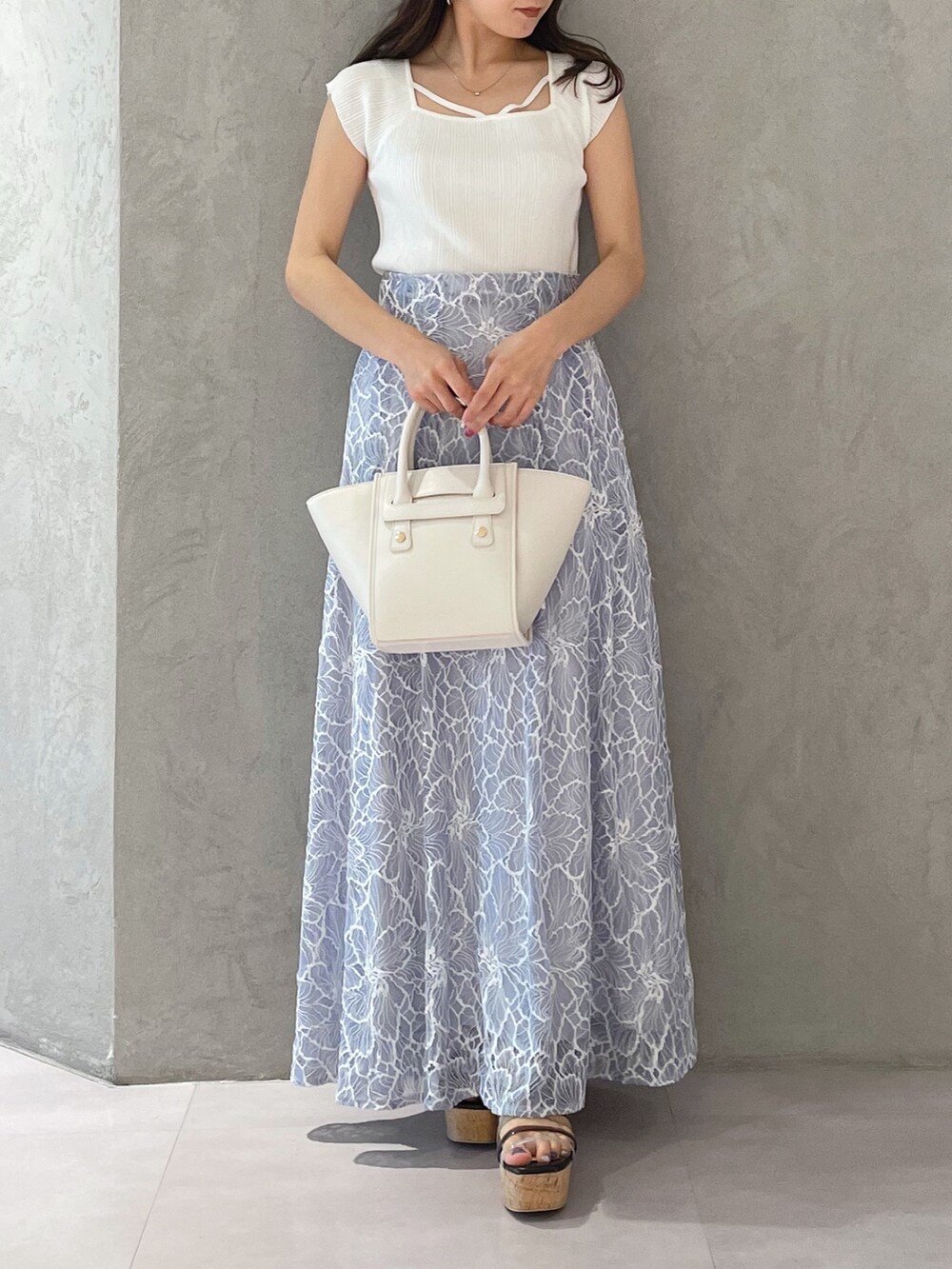 ブルー系のスカート、ブラック系のサンダル、ホワイト系のトートバッグを着用したレディースの夏コーディネートの6枚目の写真