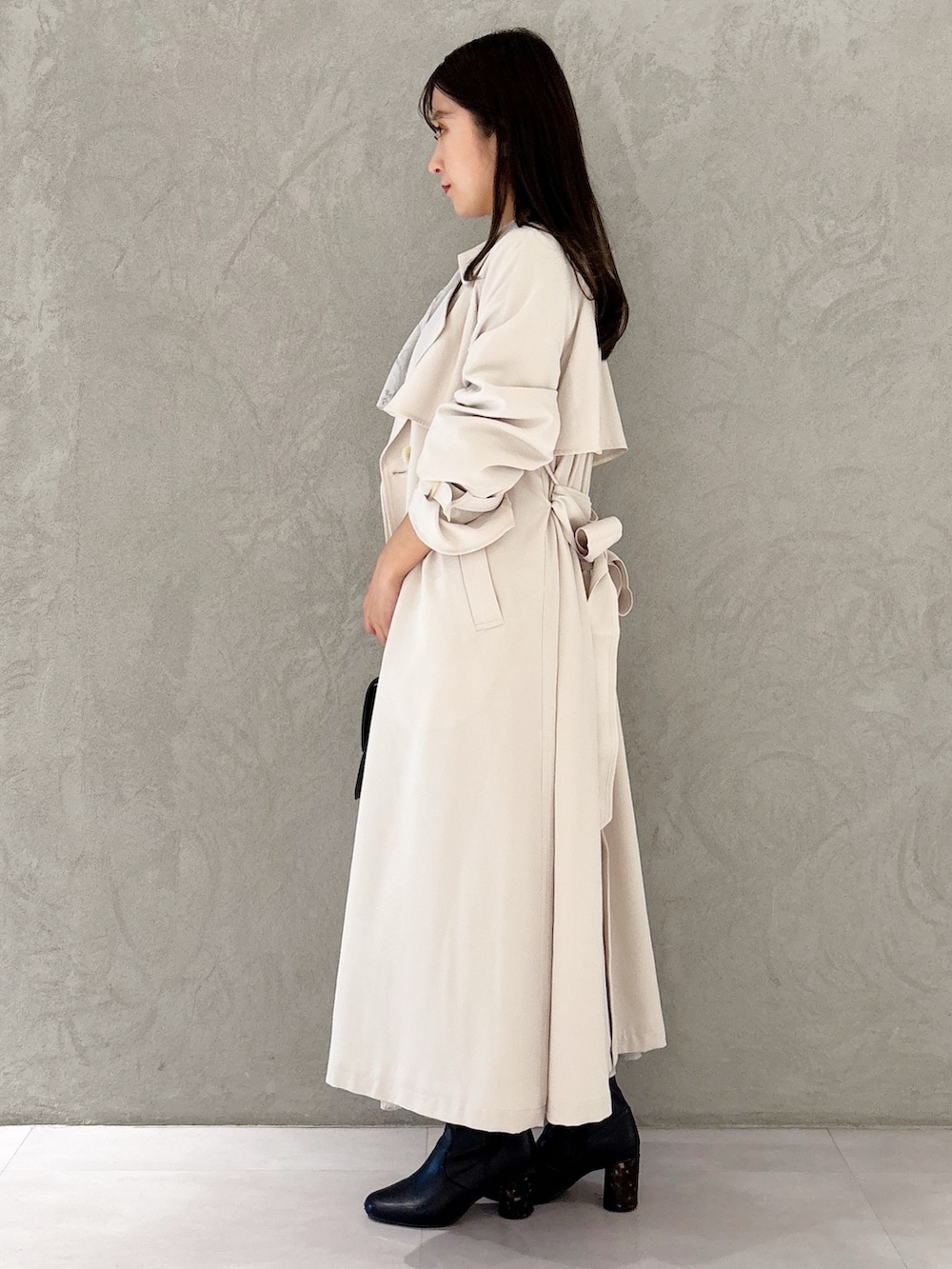 ピンク系のワンピース、ブラック系のブーツ、ブラウン系のハンドバッグを着用したレディースの春コーディネートの2枚目の写真