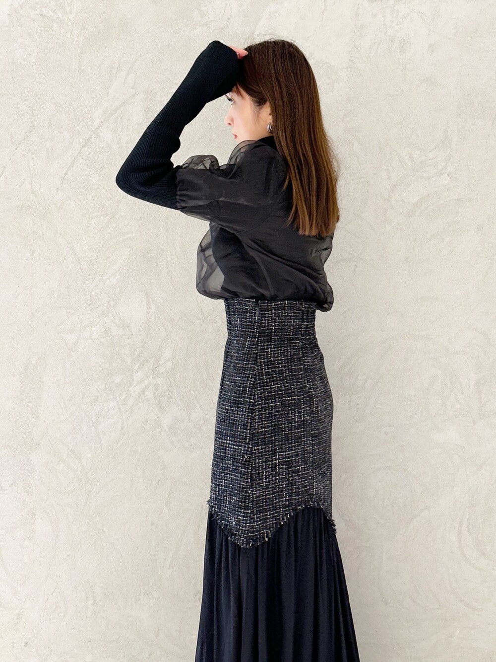 ブラック系のスカート、ブラック系のショルダーバッグ、ブラック系のブーツを着用したレディースの秋コーディネートの4枚目の写真