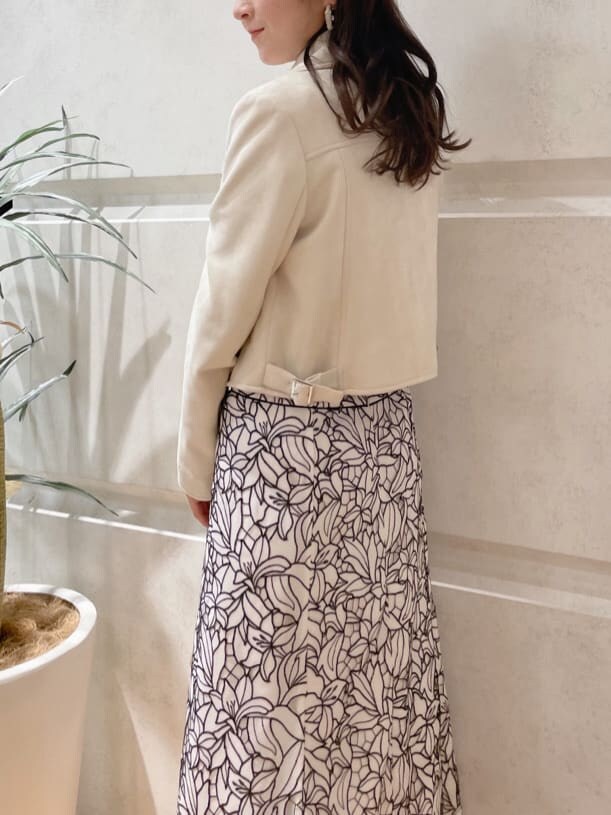 イエロー系のショルダーバッグ、ホワイト系のテーラードジャケット、グリーン系のサンダルを着用したレディースの春コーディネートの5枚目の写真