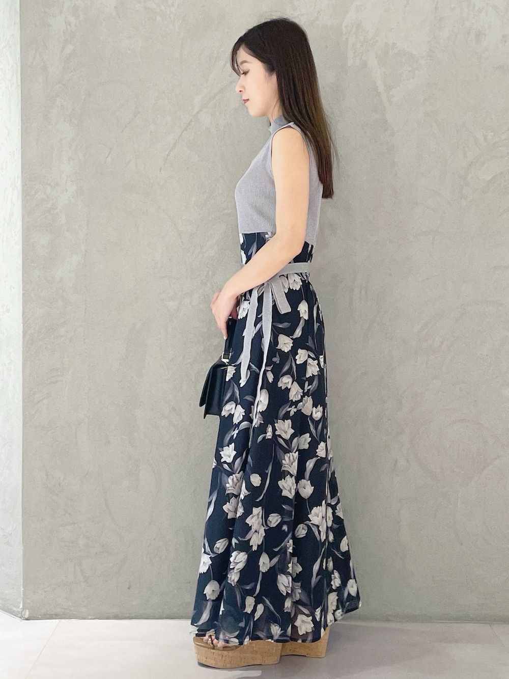 ブラウン系のサンダル、ブラック系のハンドバッグ、ブルー系のワンピースを着用したレディースの春コーディネートの2枚目の写真