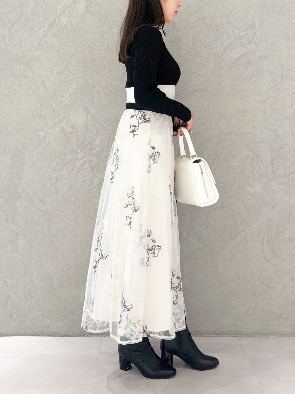 ホワイト系のワンピース、ブラック系のブーツ、ホワイト系のハンドバッグを着用したレディースの秋コーディネートの3枚目の写真