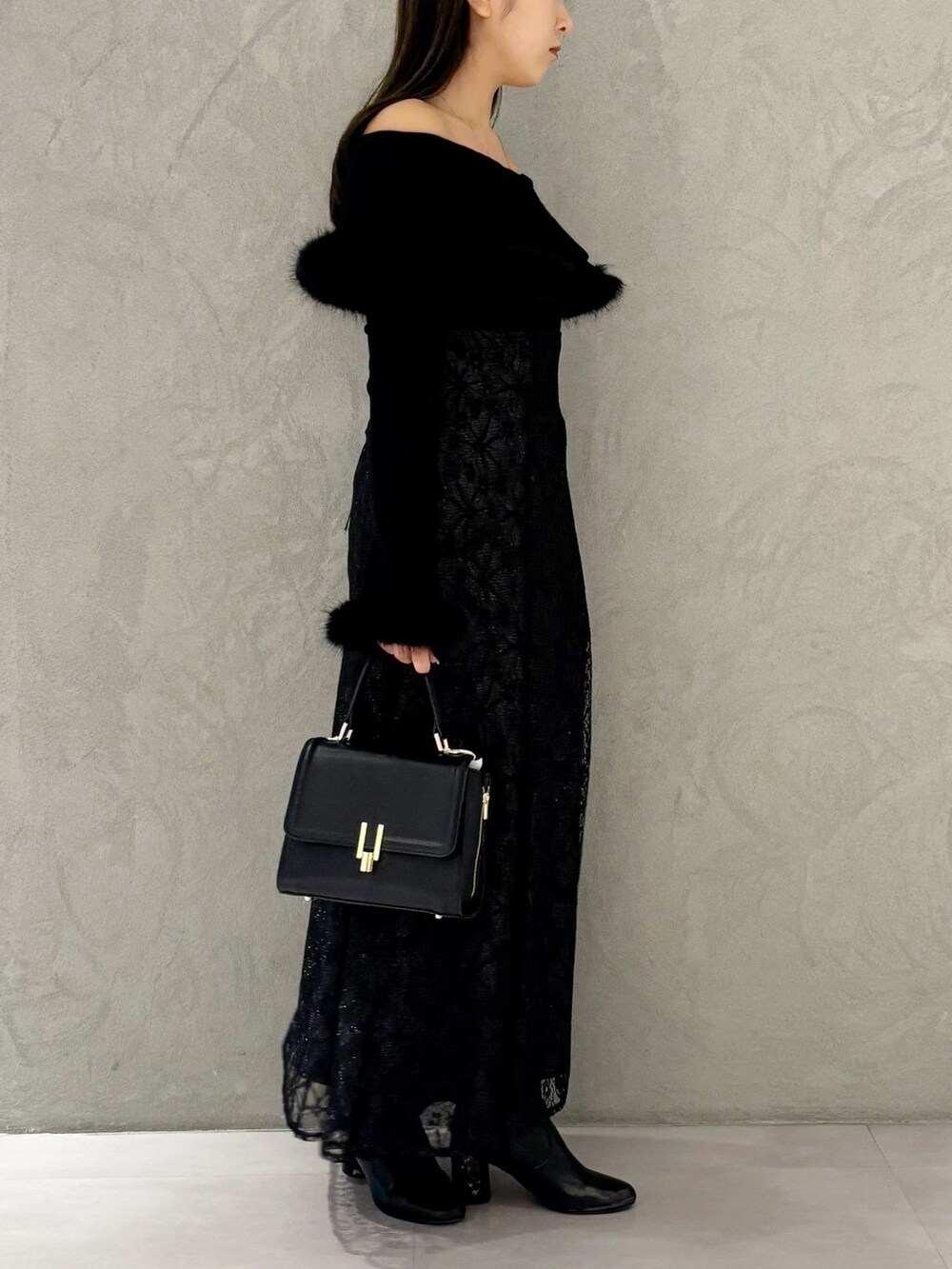 ブラック系のスカート、ブラック系のブーツ、ブラック系のショルダーバッグを着用したレディースの冬コーディネートの5枚目の写真