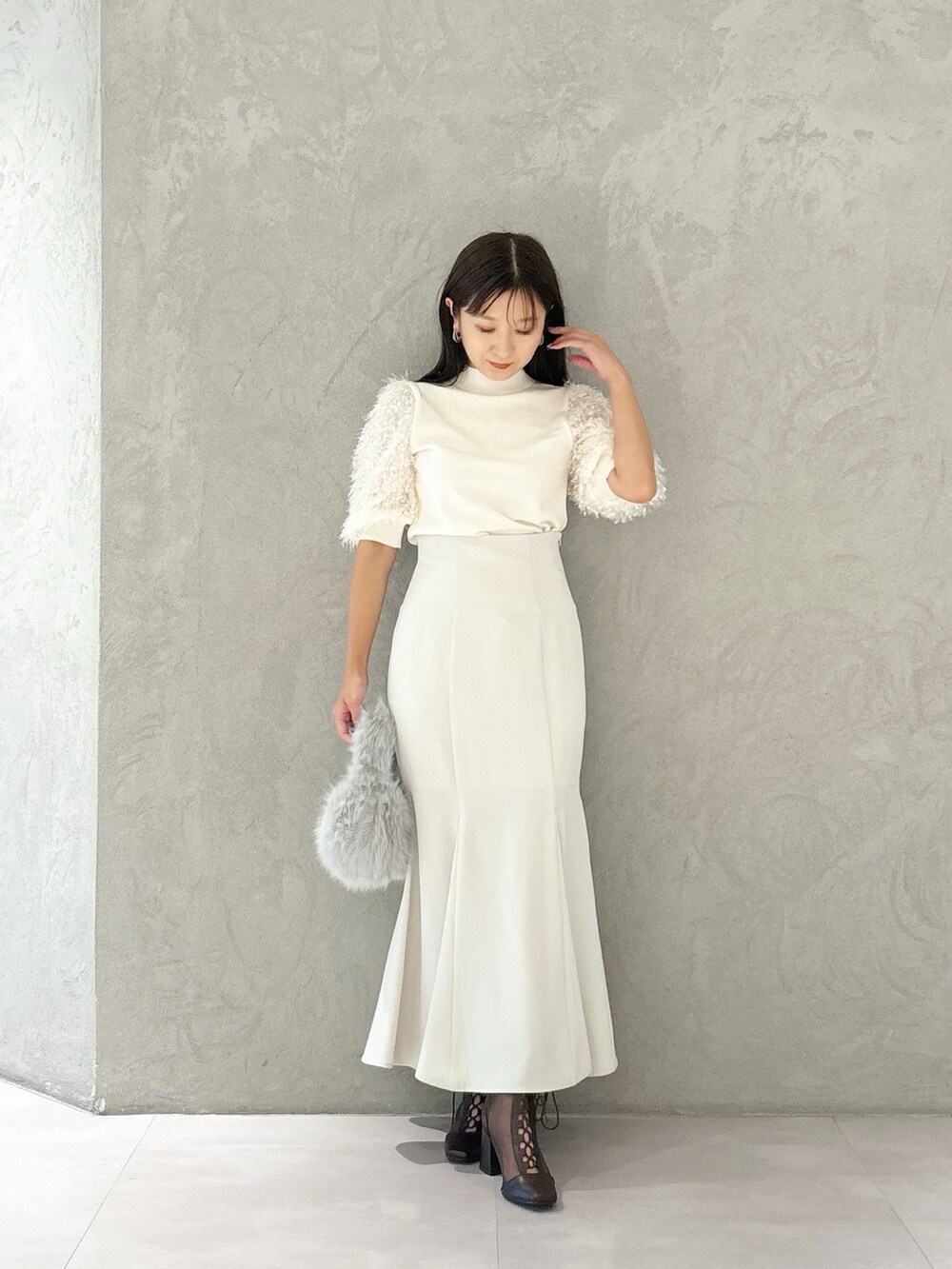 ブラウン系のブーツ、グレー系のハンドバッグ、ホワイト系のスカートを着用したレディースの夏コーディネートの6枚目の写真