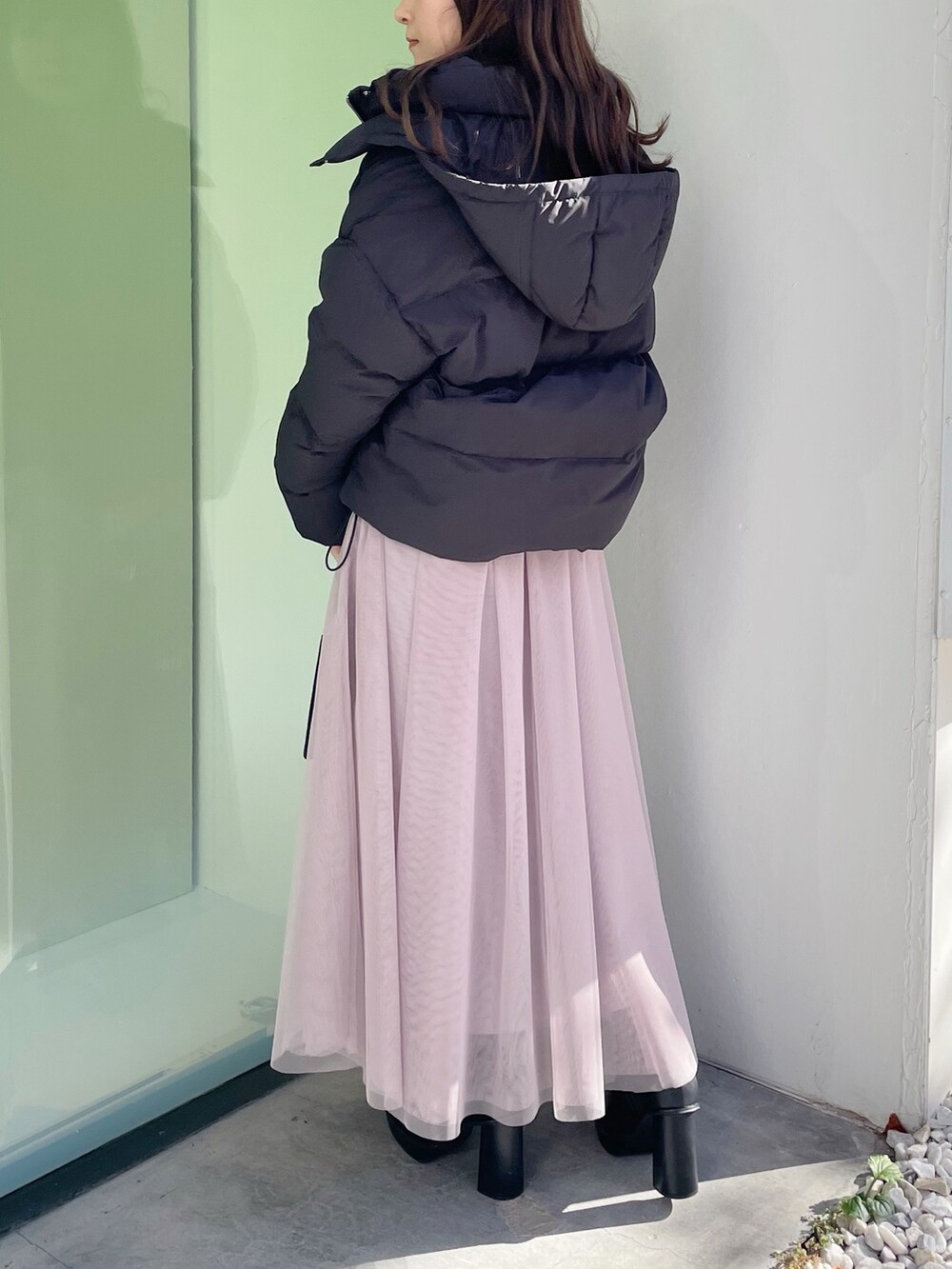 グレー系のワンピース、ブラック系のダウンジャケット/コート、ブラック系のハンドバッグを着用したレディースの冬コーディネートの4枚目の写真