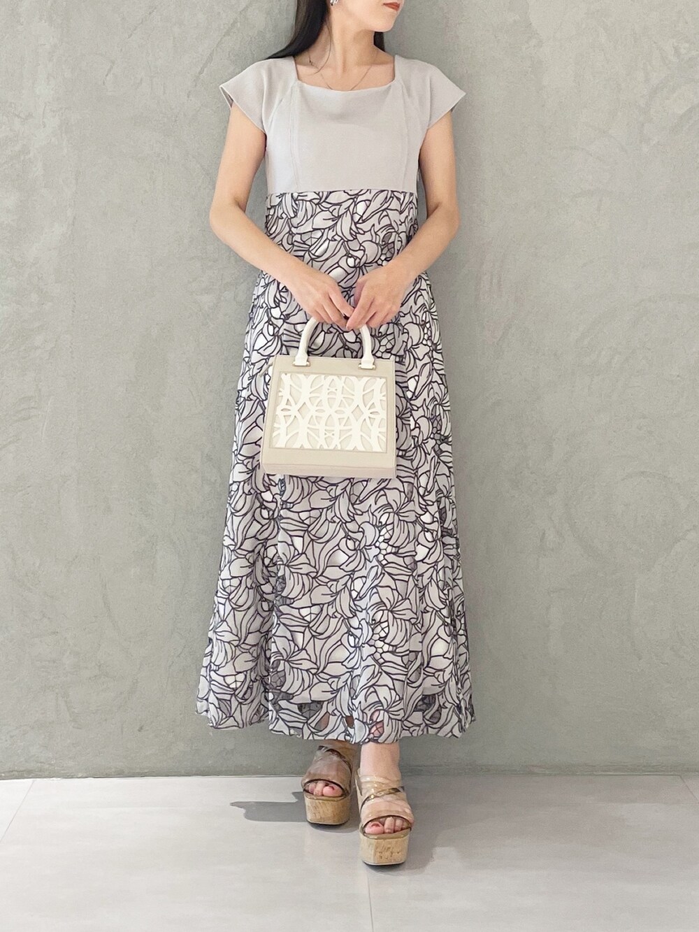 ホワイト系のショルダーバッグ、ブラウン系のサンダル、ベージュ系のワンピースを着用したレディースの春コーディネートの4枚目の写真