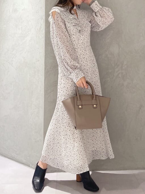 ブラウン系のハンドバッグ、ホワイト系のワンピース、ブラック系のサンダルを着用したレディースの夏コーディネートの2枚目の写真