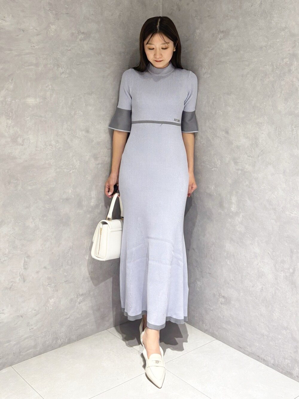 ブルー系のワンピース、ホワイト系のパンプス、ホワイト系のハンドバッグを着用したレディースの春コーディネートの7枚目の写真