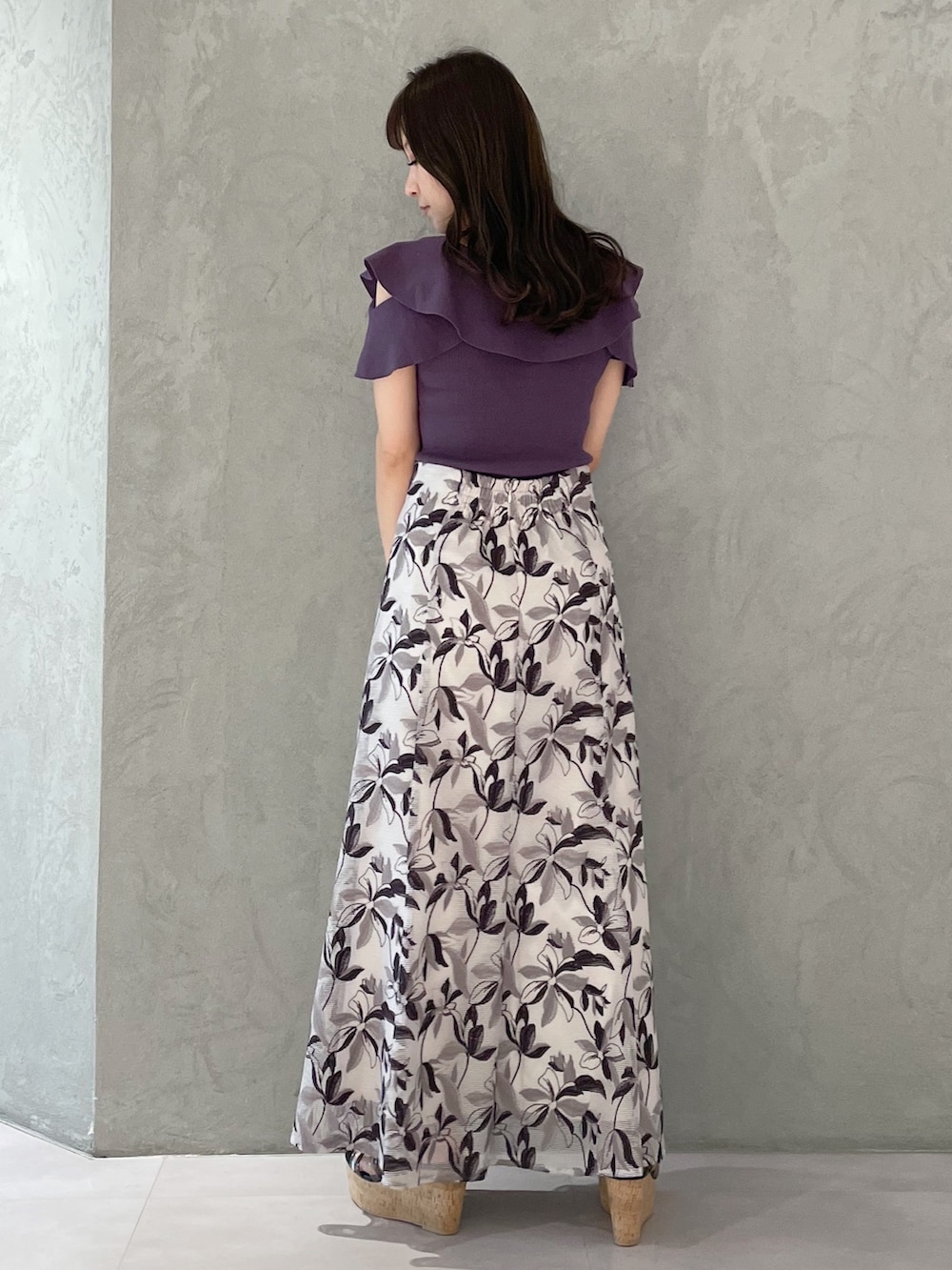 ホワイト系のハンドバッグ、ブラック系のサンダル、パープル系のニット/セーターを着用したレディースの春コーディネートの2枚目の写真