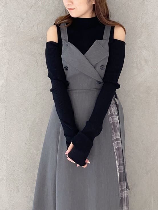 ブラック系のサンダル、ブラック系のニット/セーター、グレー系のジャンパースカートを着用したレディースの夏コーディネートの2枚目の写真