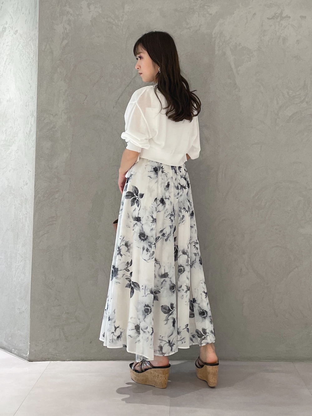 ホワイト系のワンピース、ブラック系のサンダル、ブラウン系のトートバッグを着用したレディースの夏コーディネートの3枚目の写真