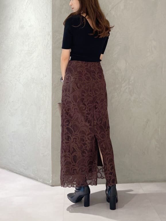 ブラウン系のハンドバッグ、ブラック系のニット/セーター、ブラック系のブーツを着用したレディースの夏コーディネートの6枚目の写真