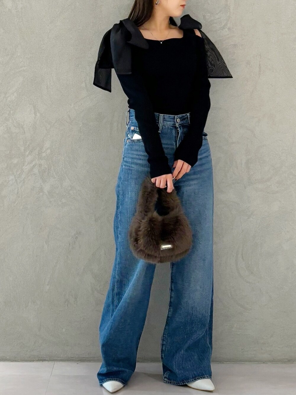 ブラウン系のハンドバッグ、シルバー系のパンプス、ブラック系のニット/セーターを着用したレディースの秋コーディネートの4枚目の写真