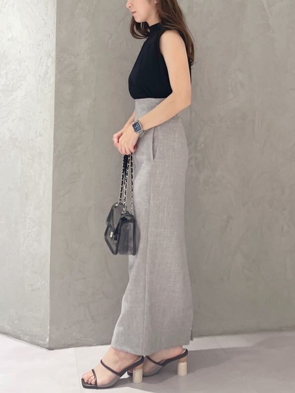 ブラック系のショルダーバッグ、ブラック系のニット/セーター、ブラウン系のサンダルを着用したレディースの夏コーディネートの3枚目の写真