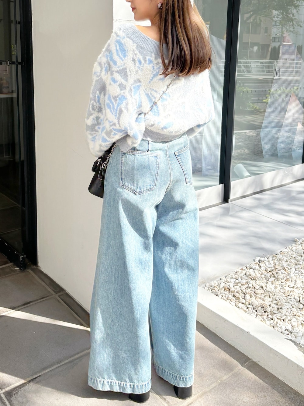 ブルー系のデニムパンツ、ブラック系のブーツ、ブルー系のニット/セーターを着用したレディースの冬コーディネートの3枚目の写真