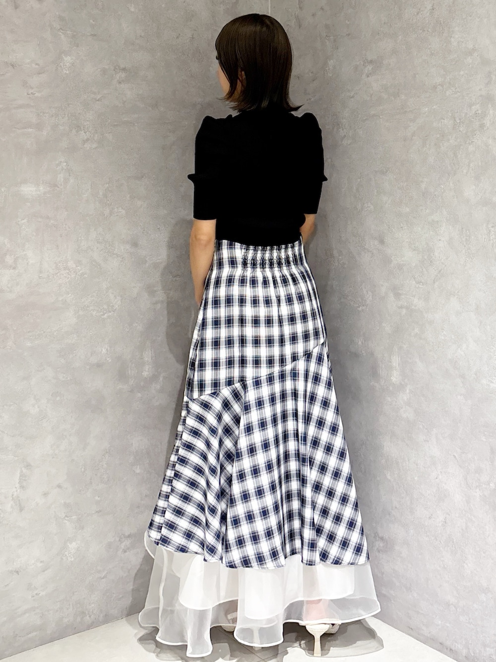 その他のスカート、ホワイト系のパンプス、ブラック系のニット/セーターを着用したレディースの春コーディネートの3枚目の写真