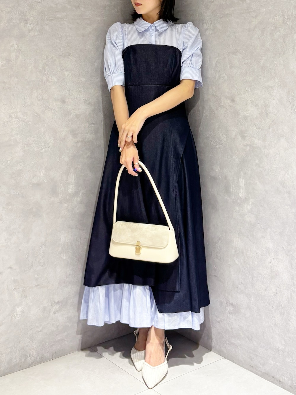 ブルー系のワンピース、ホワイト系のパンプス、ホワイト系のハンドバッグを着用したレディースの春コーディネートの5枚目の写真