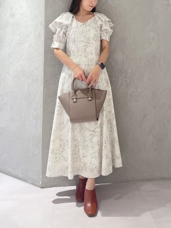 イエロー系のワンピース、ブラック系のサンダル、ブラウン系のハンドバッグを着用したレディースの夏コーディネートの8枚目の写真