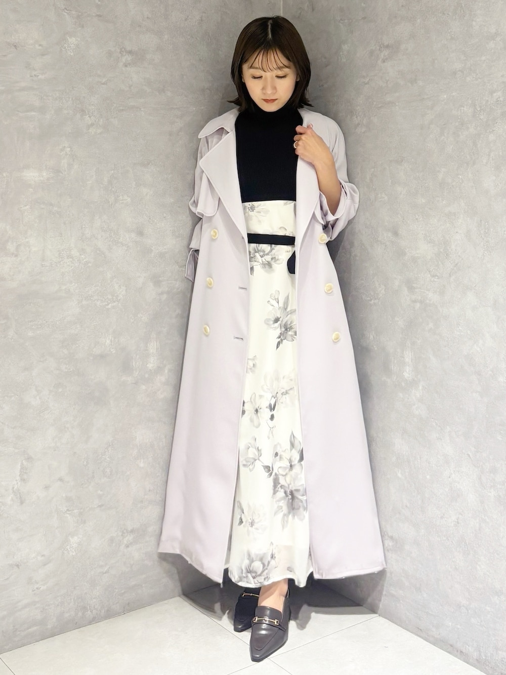 ブラック系のワンピース、ブラウン系のパンプス、パープル系のトレンチコートを着用したレディースの春コーディネートの5枚目の写真