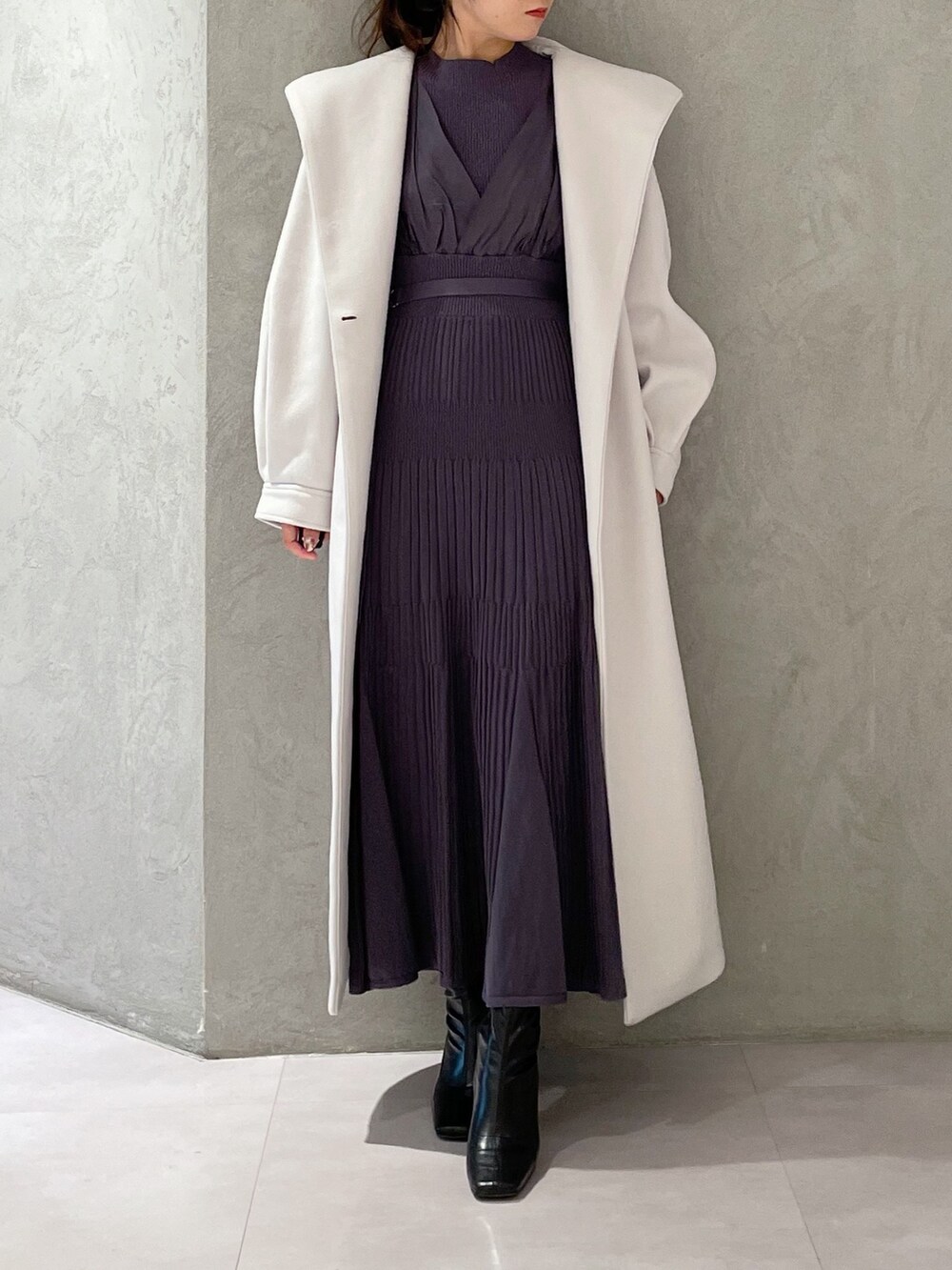 ホワイト系のチェスターコート、ブラック系のブーツ、ブルー系のワンピースを着用したレディースの秋コーディネートの6枚目の写真