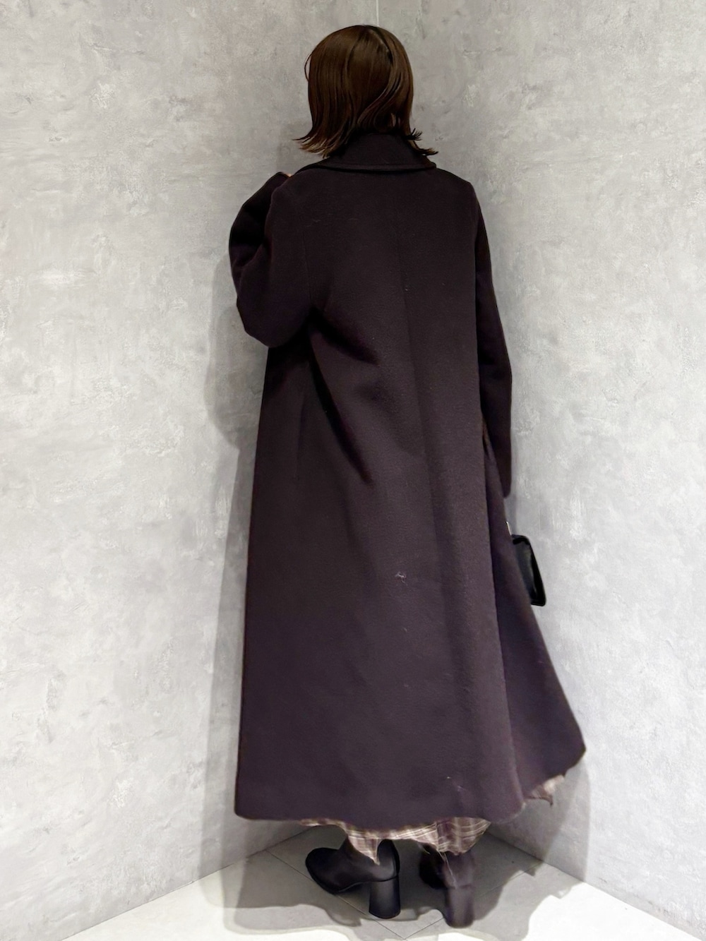 ブラウン系のチェスターコート、ブラウン系のワンピース、ブラウン系のブーツを着用したレディースの冬コーディネートの3枚目の写真