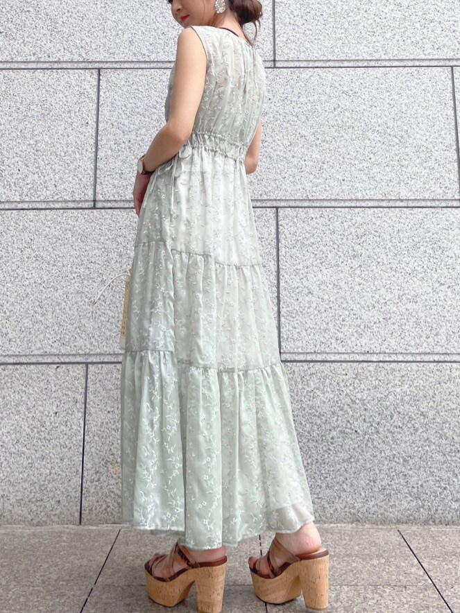 ベージュ系のサンダル、ホワイト系のハンドバッグ、グリーン系のワンピースを着用したレディースの春コーディネートの2枚目の写真