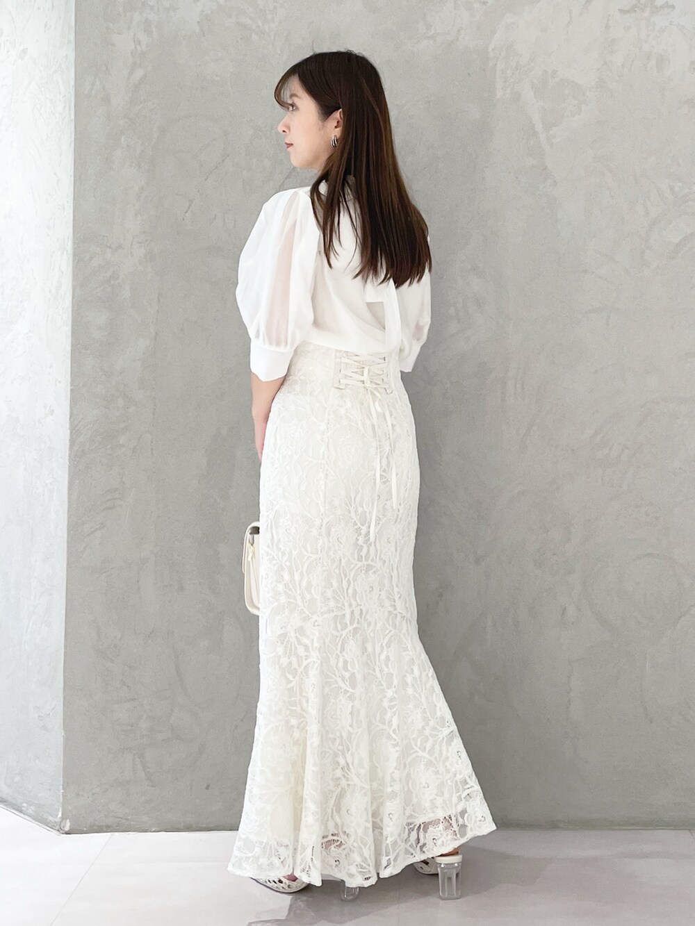 ホワイト系のスカート、ホワイト系のショルダーバッグ、ホワイト系のパンプスを着用したレディースの春コーディネートの2枚目の写真