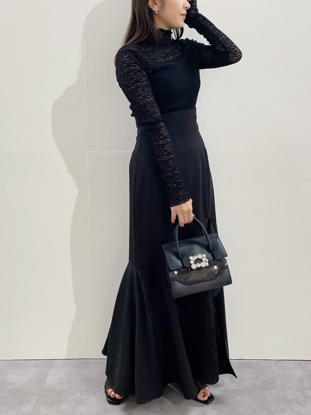 ブラック系のスカート、ブラック系のブーツ、ブラック系のTシャツ/カットソーを着用したレディースの冬コーディネートの2枚目の写真