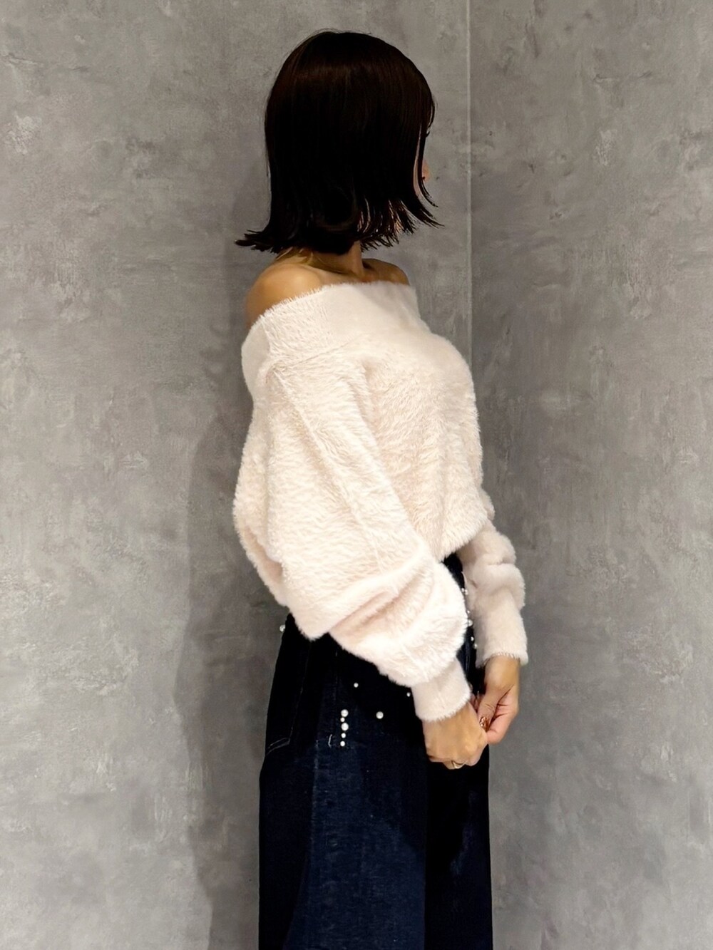 ブルー系のデニムパンツ、シルバー系のパンプス、ピンク系のニット/セーターを着用したレディースの秋コーディネートの3枚目の写真