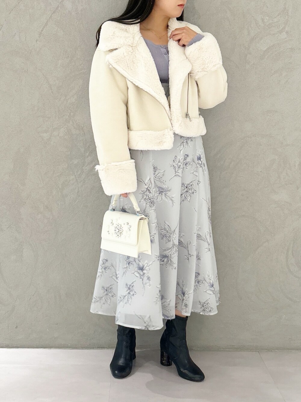 パープル系のワンピース、ブラック系のブーツ、ホワイト系のショルダーバッグを着用したレディースの秋コーディネートの7枚目の写真