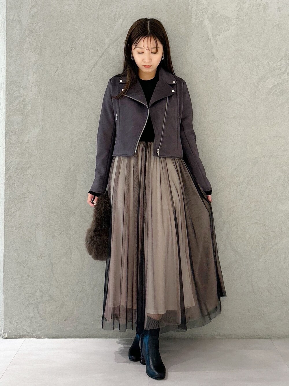 ブラック系のワンピース、ブラック系のブーツ、ブラウン系のハンドバッグを着用したレディースの秋コーディネートの6枚目の写真