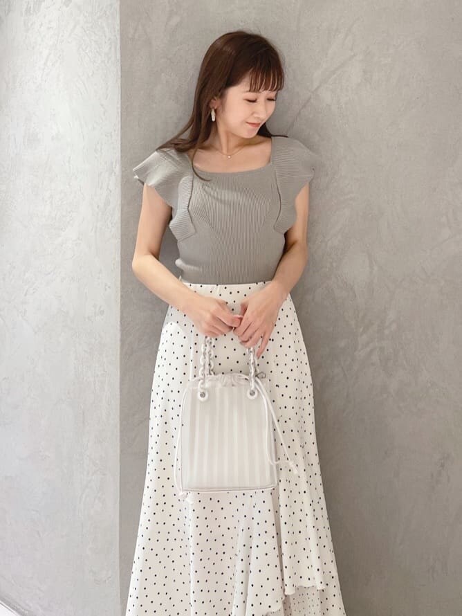 ホワイト系のハンドバッグ、グリーン系のサンダル、ホワイト系のスカートを着用したレディースの春コーディネートの5枚目の写真