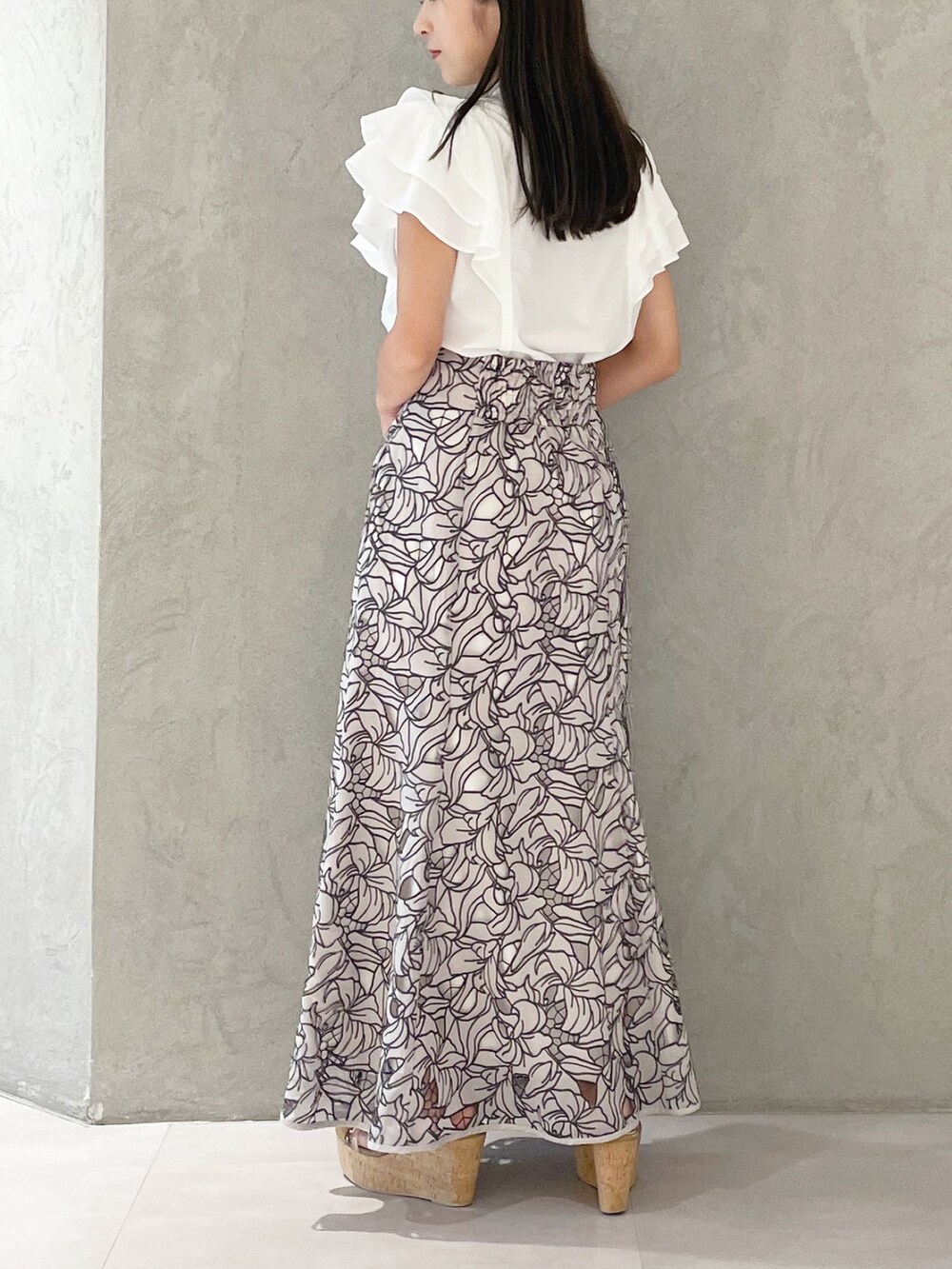 ベージュ系のスカート、ブラウン系のサンダル、ホワイト系のショルダーバッグを着用したレディースの夏コーディネートの3枚目の写真