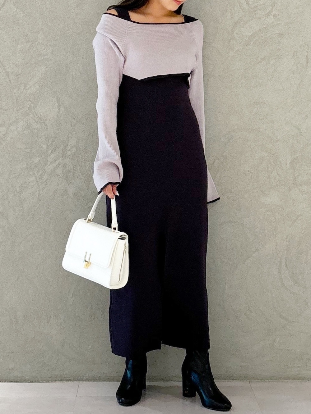 グレー系のワンピース、ブラック系のブーツ、ホワイト系のハンドバッグを着用したレディースの秋コーディネートの5枚目の写真