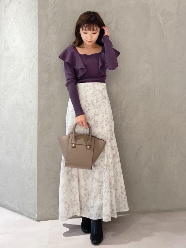 ピンク系のスカート、ブラウン系のハンドバッグ、パープル系のニット/セーターを着用したレディースの秋コーディネートの8枚目の写真