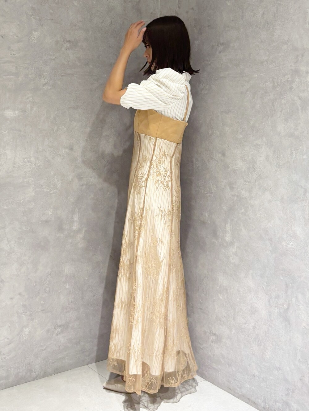 ベージュ系のワンピース、シルバー系のパンプス、ホワイト系のハンドバッグを着用したレディースの夏コーディネートの2枚目の写真