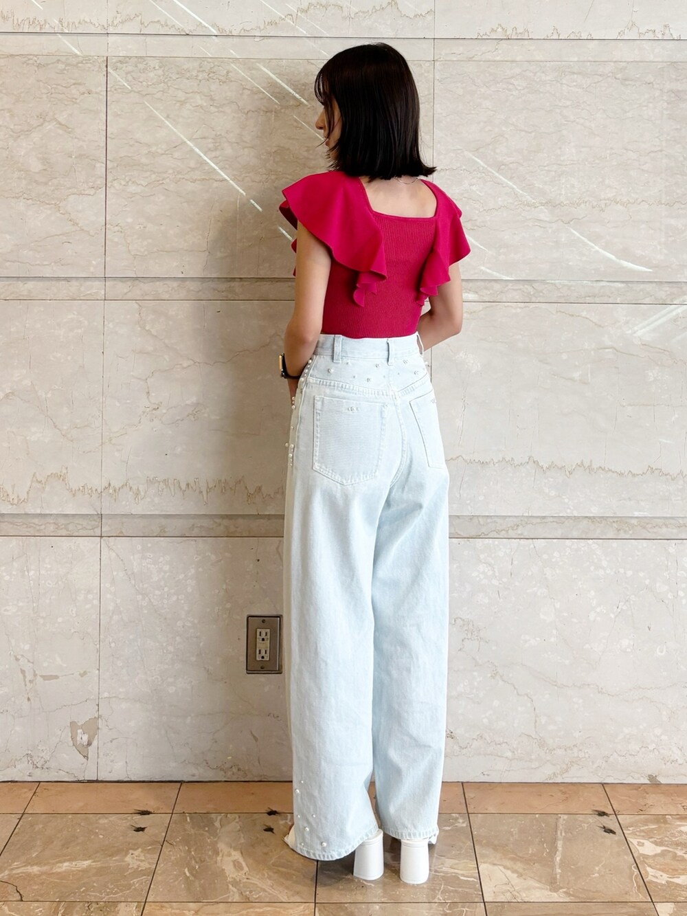 ブルー系のデニムパンツ、ホワイト系のサンダル、レッド系のニット/セーターを着用したレディースの夏コーディネートの3枚目の写真