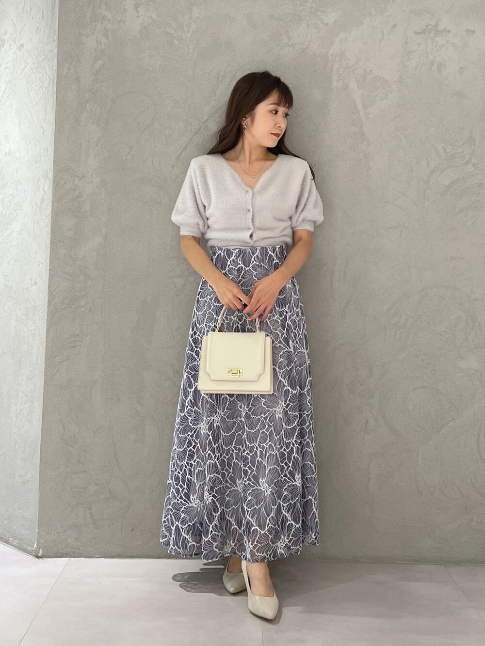 グレー系のカーディガン/ボレロ、ホワイト系のハンドバッグ、ホワイト系のパンプスを着用したレディースの夏コーディネートの4枚目の写真