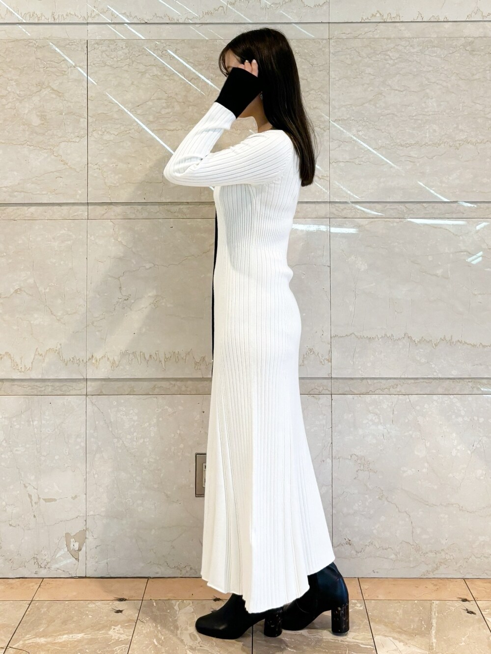 ホワイト系のワンピース、ブラック系のブーツを着用したレディースの冬コーディネートの6枚目の写真